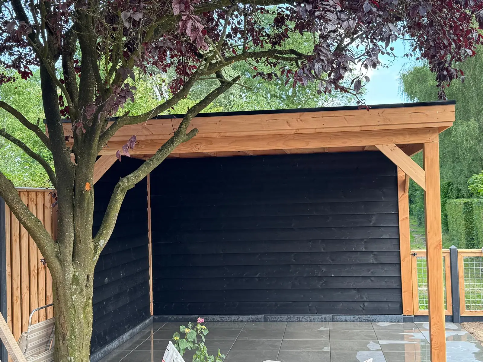 Houten overkapping in een volgroeide tuin